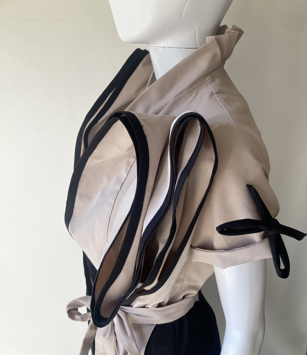 Preklopna haljina napravljena od crne i Pearl boje. Atraktivni volani aplicirani na prednjem dijelu. Džepovi u bočnim šavovima. Wrap dress made of black and pearl color. Attractive ruffles applied on the front. Pockets in the side seams.